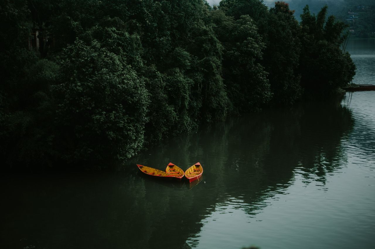 Calm green water of Begnas Lake framed by terraced hills near Pokhara, Nepal