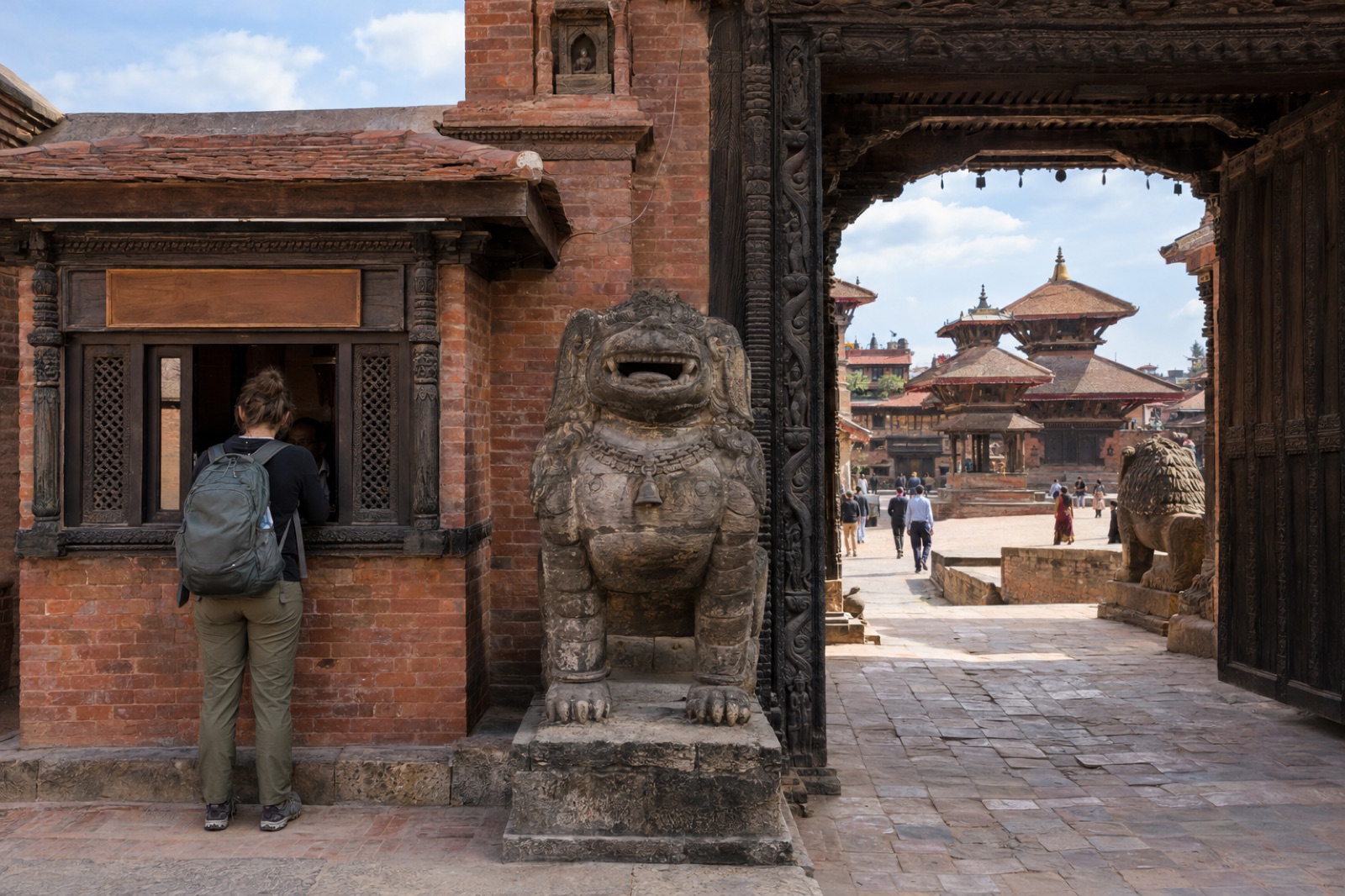 A traveller buying a ticket at the brick entrance booth of Bhaktapur Durbar Square