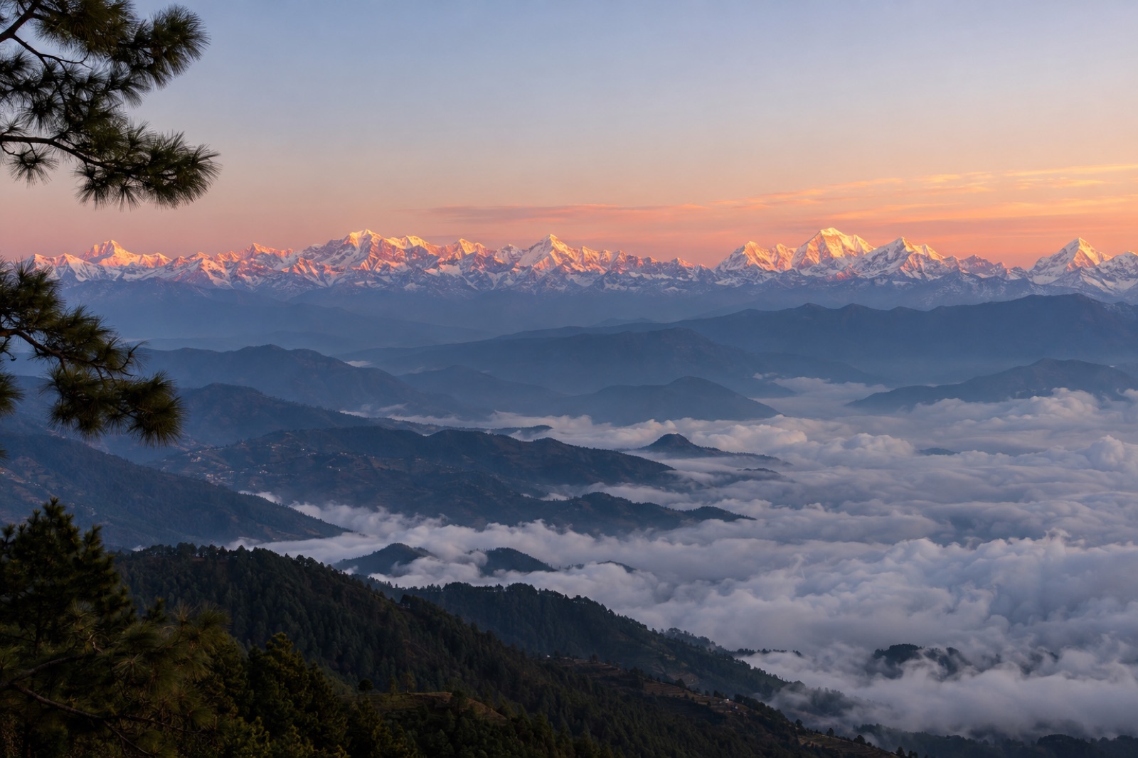 Dawn from the Daman ridge: an unbroken wall of snow peaks above layered foothills and a sea of cloud