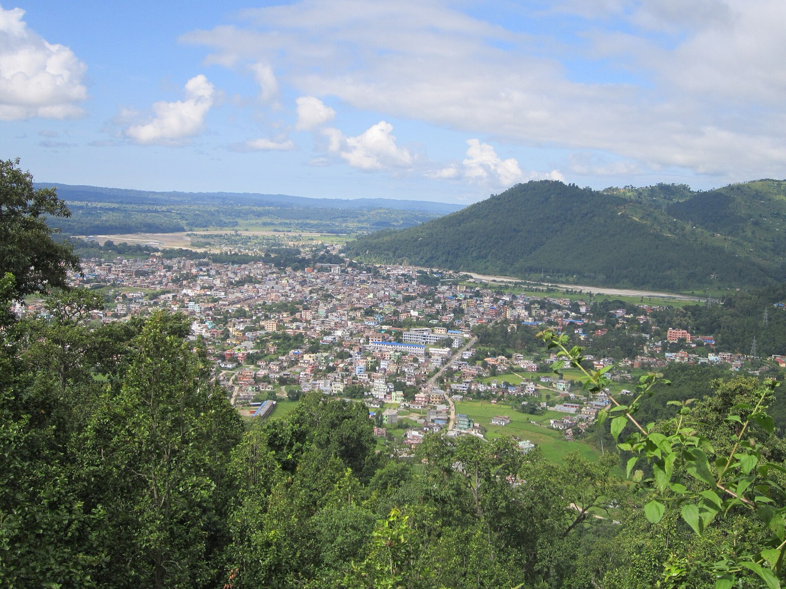 Hetauda spread across its green valley in Makwanpur, seen from the forested hills above, with the Terai plain beyond