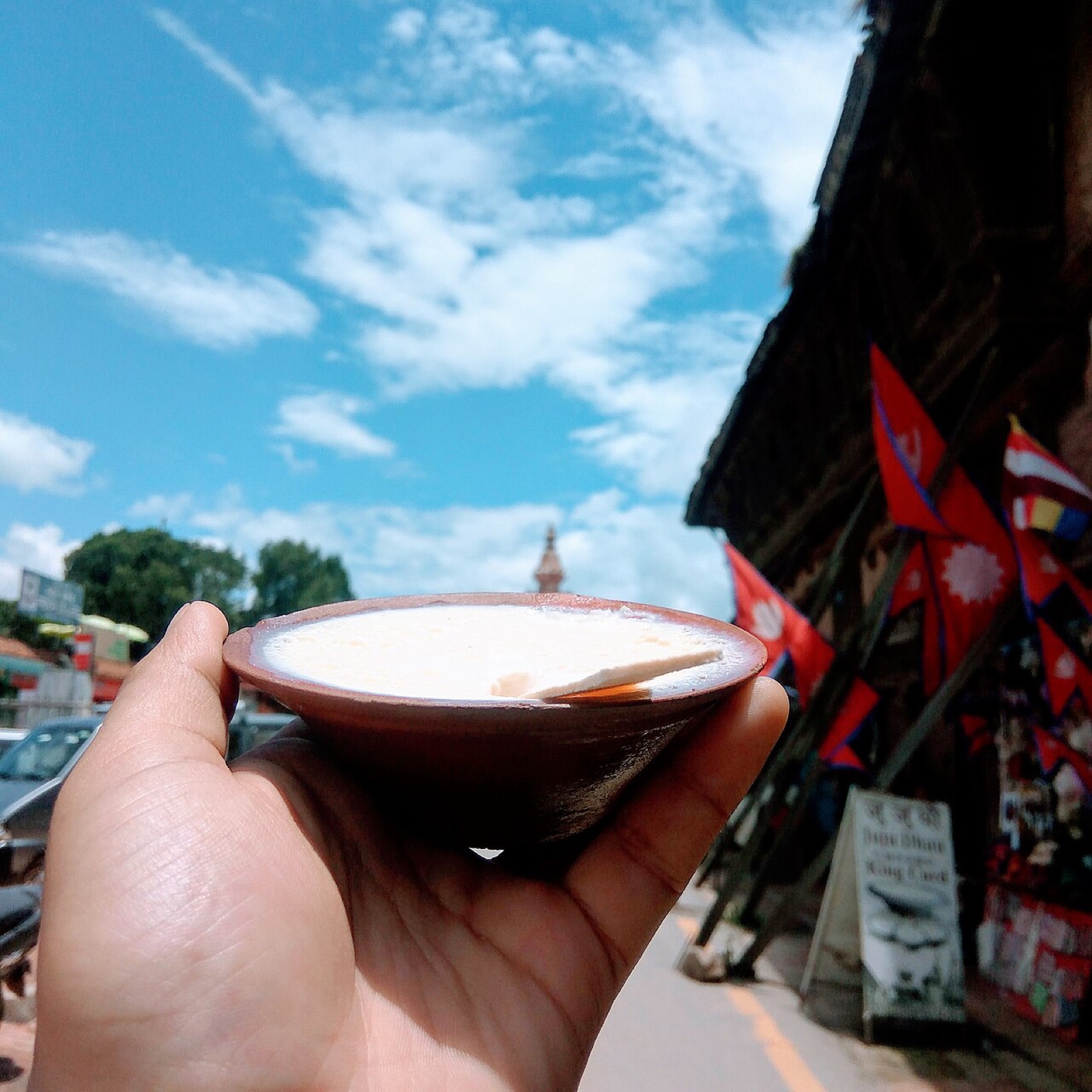 A clay pot of juju dhau, Bhaktapur’s sweet set yoghurt, held up in the street